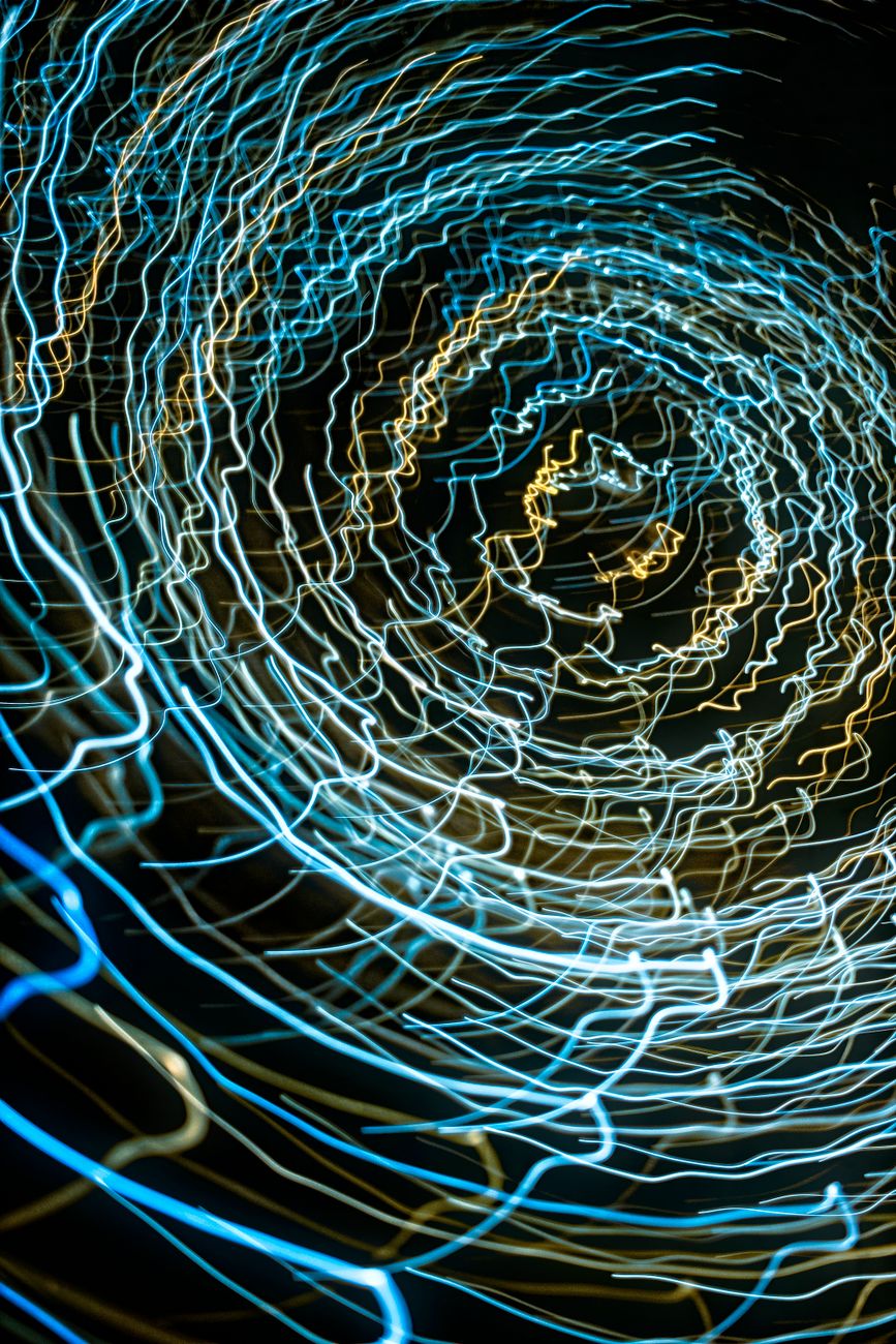 dynamic spiral of blue and gold light trails